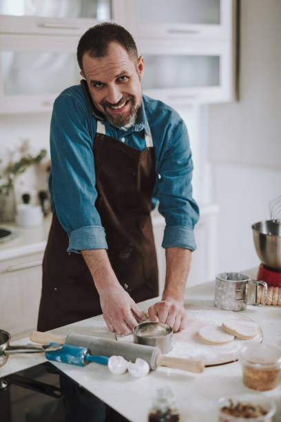 istock Happy man smiling to and having phone talk while cooking 1138147662
