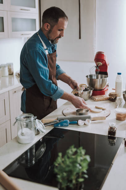 istock Concentrated man having raw cookies on the table 1138147666