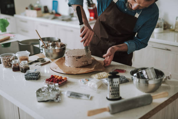 istock Kitchen table full of products and man making cake 1138147722