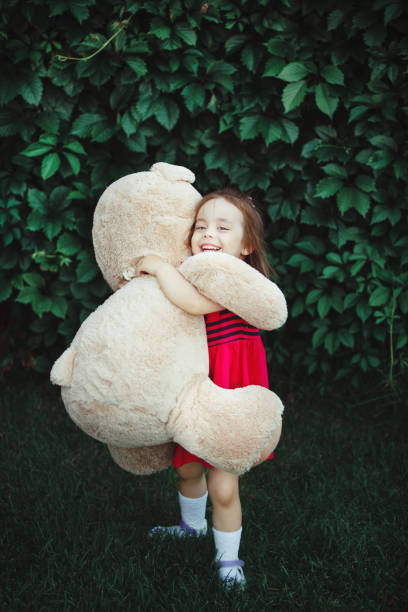 istock Happy girl hugging a big toy bear. 1138151101