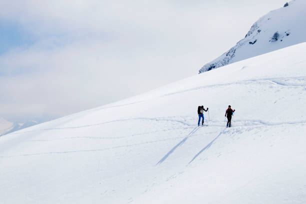istock couple going up a mountain in a touring ski day 1138152934