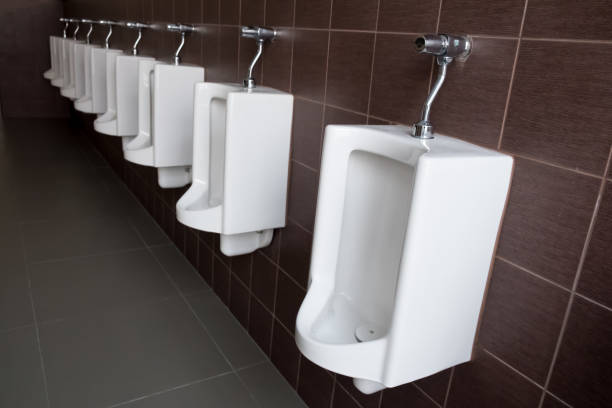 urinoirs blancs dans les toilettes publiques des hommes. urinoir d'homme dans le modèle classique - urinal public restroom male toilet in a row photos et images de collection