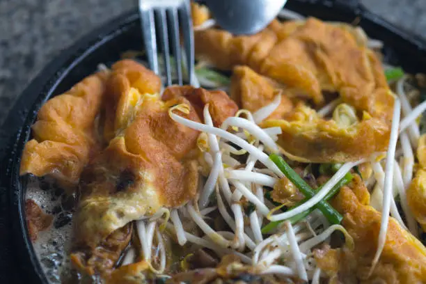 Crisp fried mussels pancake with beansprout on hot pan. It called Hoi Tod is Thai traditional