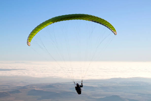 istock man paragliding in a sunny day over mountains 1138154129