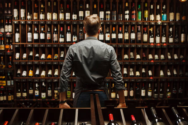 istock Bartender at wine cellar full of bottles with exquisite drinks 1138155236