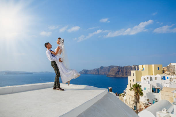 Beautiful wedding couple Beautiful wedding couple on the background of the sea and the island of Santorini happy couple on vacation in santorini greece stock pictures, royalty-free photos & images