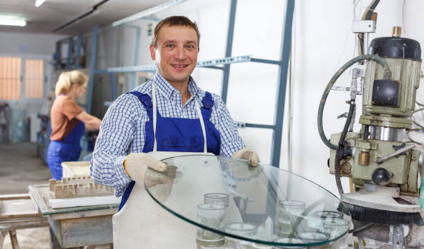 istock Craftsman working on machine for curved glass faceting 1138157477