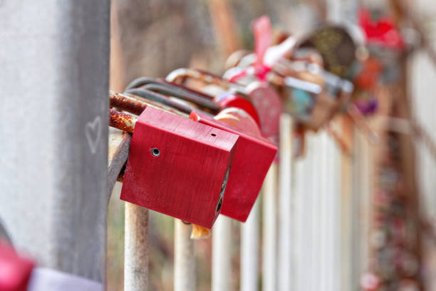 red old locks hang on iron fence on the road of love in Riomaggiore on Ligurian coast in Italy