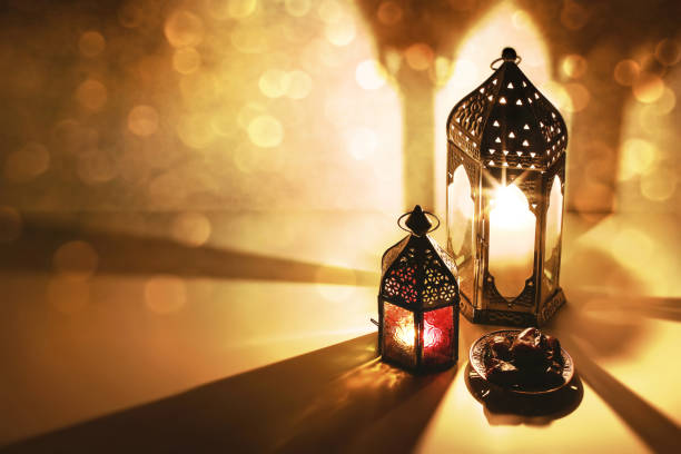 istock Moroccan Arabic lanterns, burning candles glowing at night. Date fruit on the table. Greeting card, invitation for Muslim Ramadan Kareem holiday. Iftar dinner background with golden bokeh lights. 1138158794