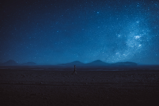 Woman walks under the million stars and Milky Way in Atacama desert