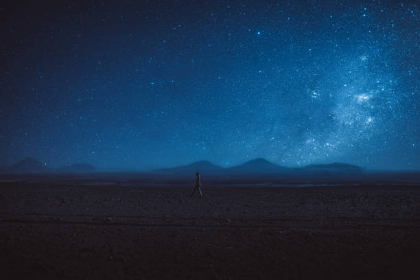 Woman walks under the million stars and Milky Way in Atacama desert Woman stargazing at Atacama desert in Chile near the mountains at night volcano photos stock pictures, royalty-free photos & images