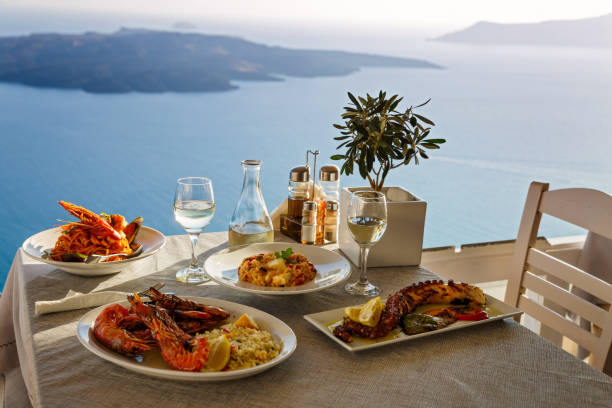 Romantic dinner for two Romantic dinner for two at sunset.Greece, Santorini, restaurant on the beach, above the volcano. meditteranean food stock pictures, royalty-free photos & images