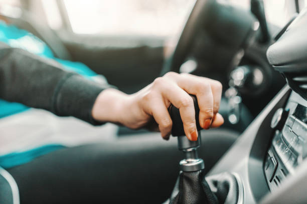 Close up of pregnant Caucasian young woman driving car and holding hand on gearshift. Close up of pregnant Caucasian young woman driving car and holding hand on gearshift. gearshift photos stock pictures, royalty-free photos & images