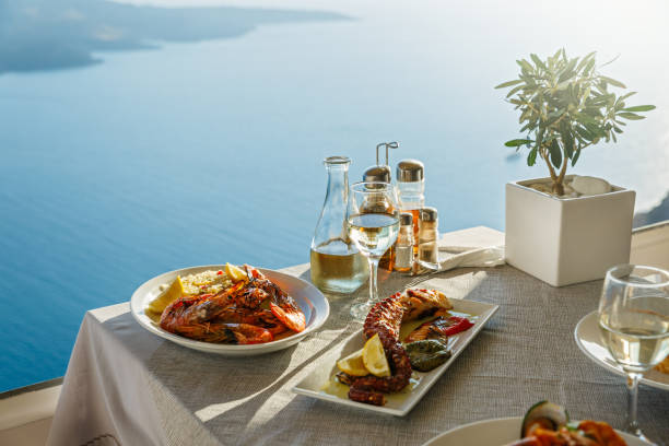 cena per due con piatti di pesce e vino bianco - mar mediterraneo foto e immagini stock