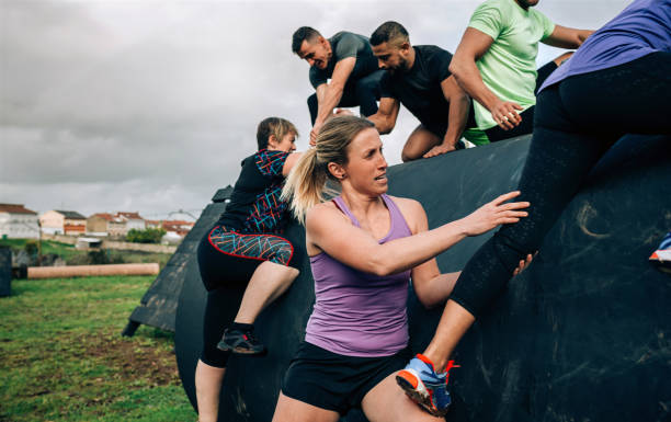 istock Participants in an obstacle course climbing a drum 1138160685