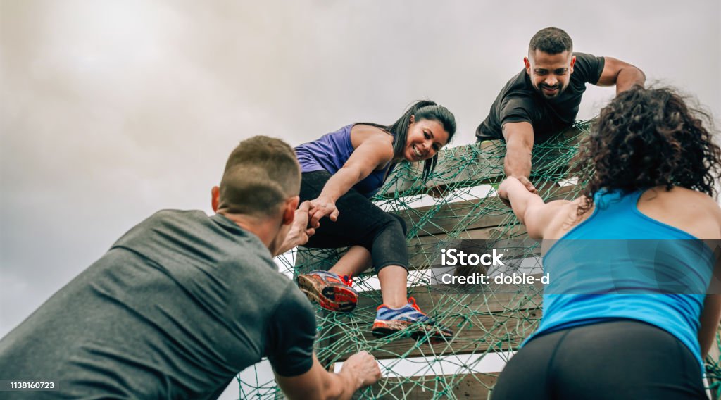 Participants au filet d'escalade de parcours d'obstacles - Photo de Travail d'équipe libre de droits