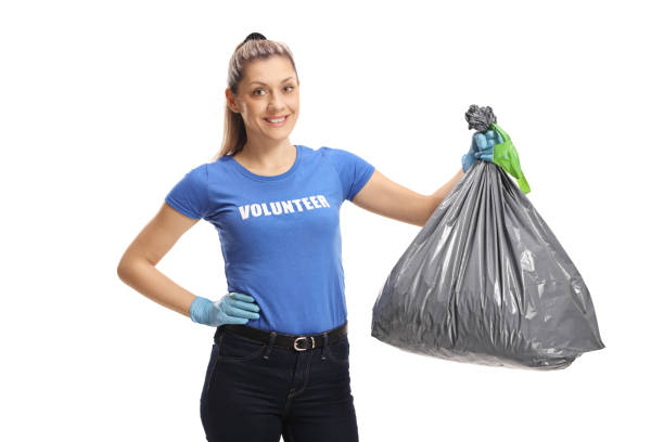 istock Cheerful young female volunteer holding a garbage bag 1138161707