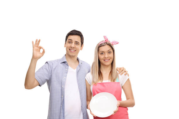 Young couple showing a clean plate isolated on white background