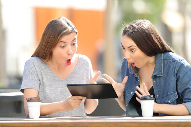 istock Two amazed friends watching media in a tablet 1138162032