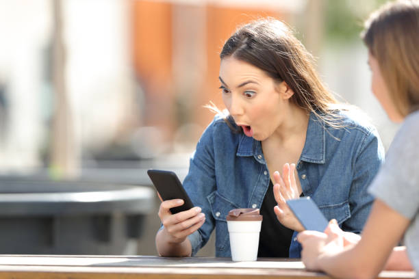 istock Surprised woman checking phone online content in a park 1138162332