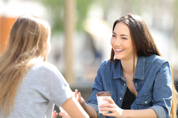 zwei freunde reden kaffee in einem park - speech talking teenager student stock-fotos und bilder