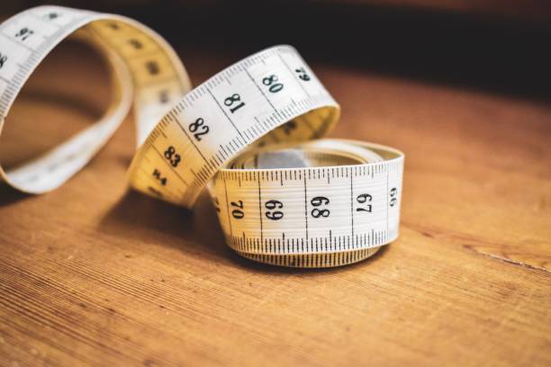 White Tailor Measuring Tape On A Wood Table Stock Photo - Download