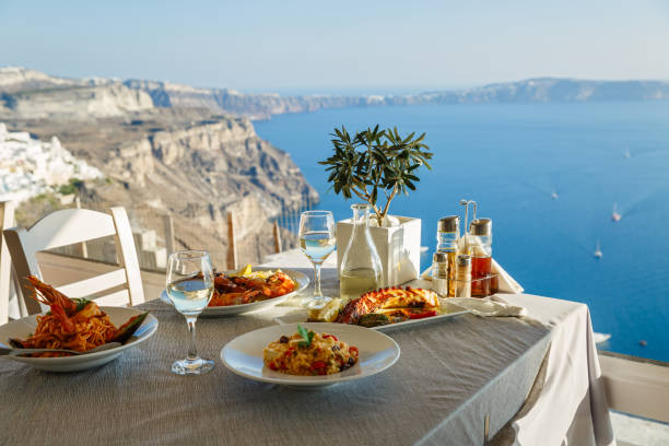 cena per due con piatti di pesce e vino bianco - cibo di mediterraneo foto e immagini stock