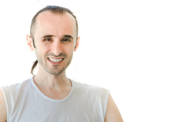 Young handsome hipster man in white sleeveless shirt. Studio shot on gray background.