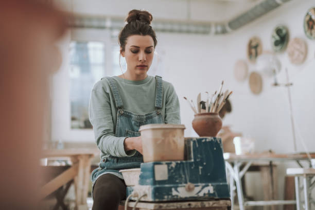 istock Beautiful young woman working on pottery wheel 1138166691