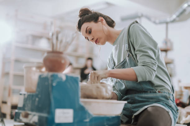 schöne junge dame, die auf töpferrad arbeitet - keramiker stock-fotos und bilder