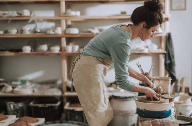 istock Beautiful young lady in apron working in pottery workshop 1138166725