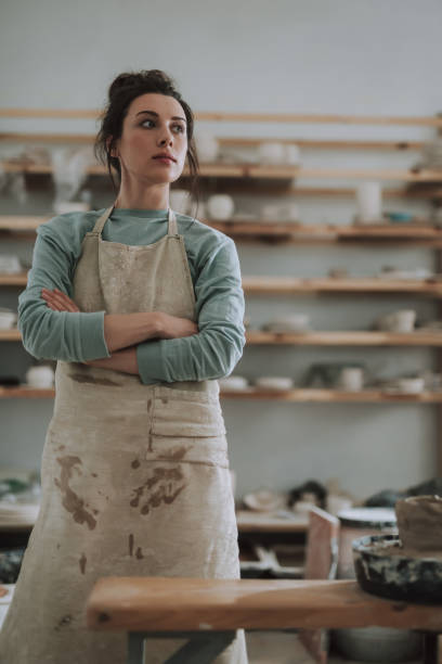 istock Pretty young woman with folded arms standing in pottery workshop 1138167275
