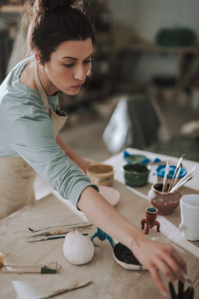 istock Beautiful young lady in apron working in pottery workshop 1138167289