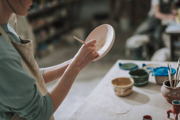 istock Young woman painting ceramic plate at workshop 1138167300