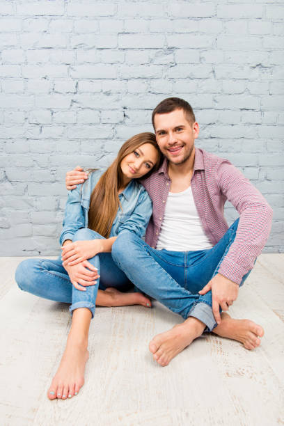 istock Handsome man sitting on the floor and embracing his girlfriend 1138167315