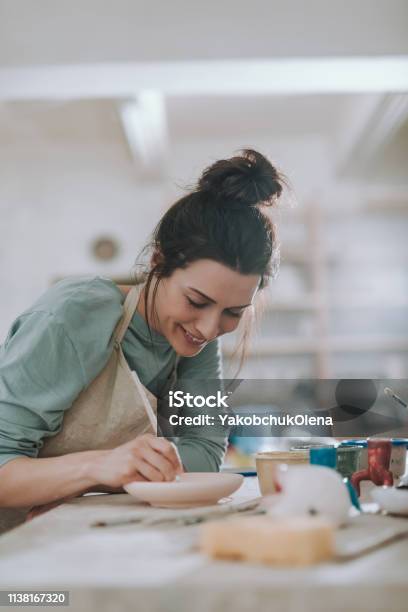 Cheerful Young Woman Painting Pottery At Workshop Stock Photo - Download Image Now - Painting - Activity, Painting - Art Product, Women