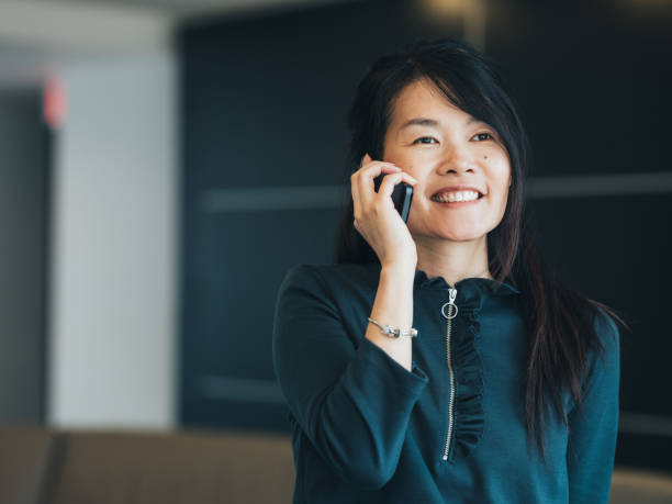 istock Young Asian woman using mobile phone at work 1138168915
