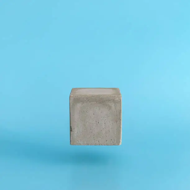 Photo of Levitating cube pedestal on blue background.