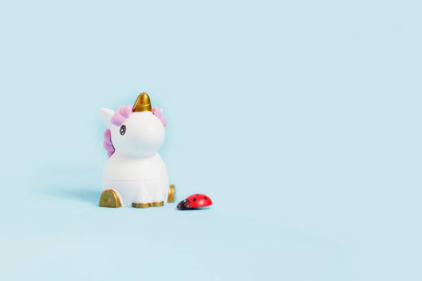 istock white toy unicorn and ladybug on a blue background 1138169859