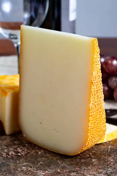 Pieces of french yellow cheeses, Pur Brebis sheep melk cheese fron Pyrenees and Saint Paulin creamy, mild, semi-soft French cheese from pasteurized cow milk
