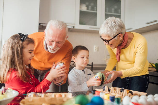 istock Happy couple decorating Easter eggs with grandchildren 1138172177