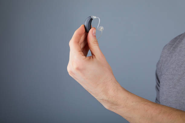 holding small black hearing aid stock photo