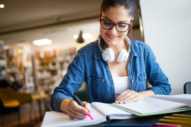 istock College woman studying at the library looking happy 1138174781