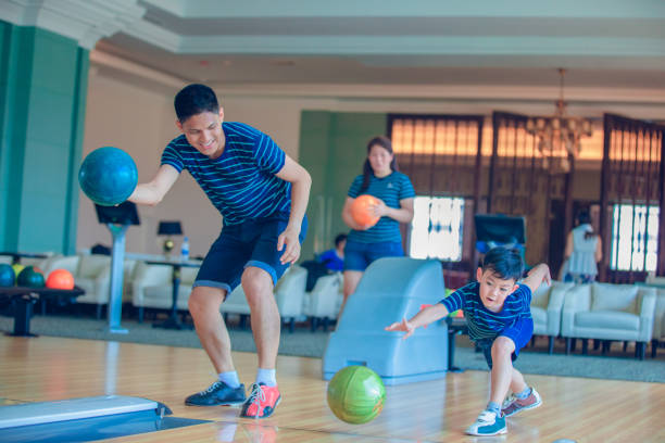 filho de ensino do pai e bowling do jogo da família no clube do bowling no tempo do relax - bowler - fotografias e filmes do acervo