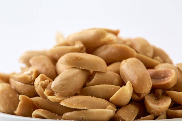 istock Roasted peanuts and salt in a bowl on a white background 1138183210