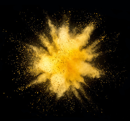 Explosión de polvo dorado sobre fondo negro photo