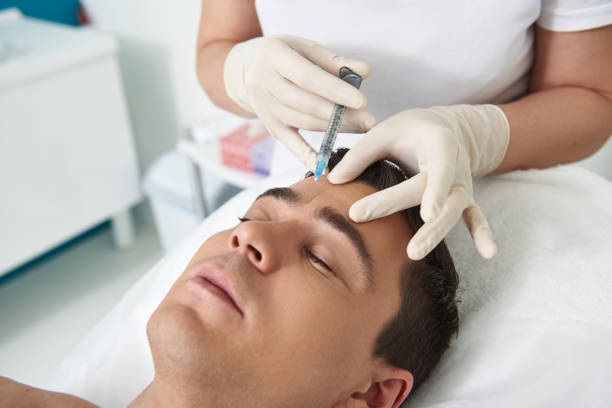 istock Young man lying on couch on botox procedure 1138186472