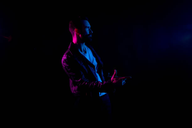 istock Attractive man with white shirt and leather jacket and gel lighting 1138189863