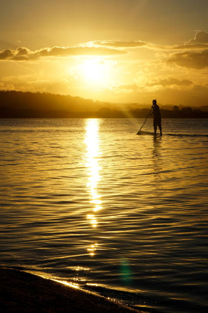 istock man practicing stand up paddle on the lagoon at sunset 1138191255