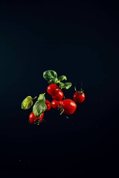 チェリートマトとバジルの食品爆発 - cherry tomato flash ストックフォトと画像